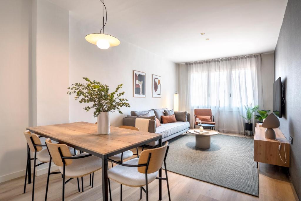 un soggiorno con tavolo e divano di Arrivo Apartments a Barcellona
