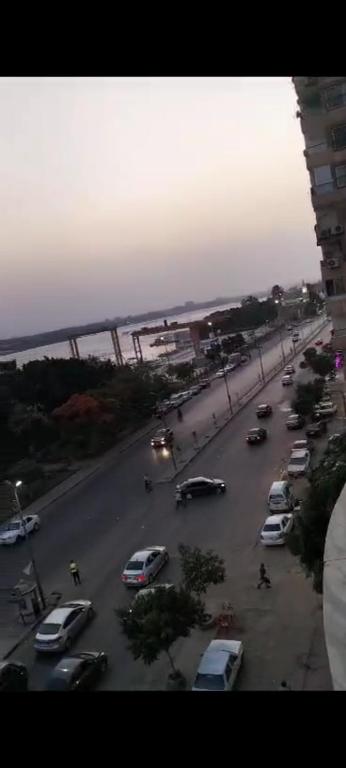 vistas a una calle con coches aparcados en la carretera en شقه سكنيه, en El Cairo