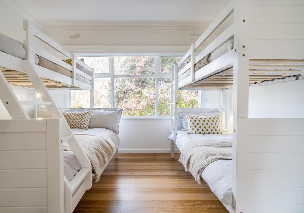 two bunk beds in a room with a window at Peninsula Luxury Beach House FREE WI-FI in Rosebud