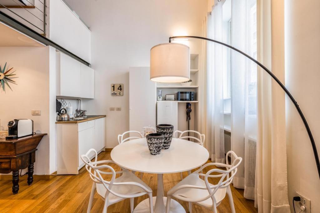 een keuken en eetkamer met een tafel en stoelen bij Loft Crocetta in Turijn