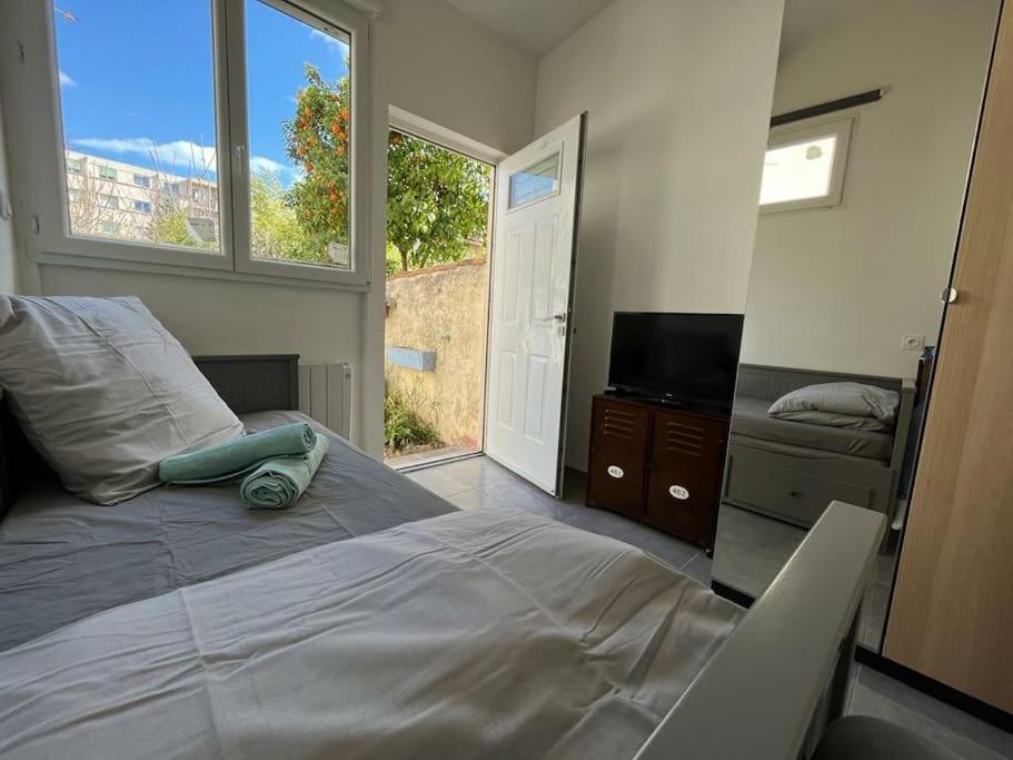 une chambre avec un grand lit et une télévision dans l'établissement Citronnier, à Marseille