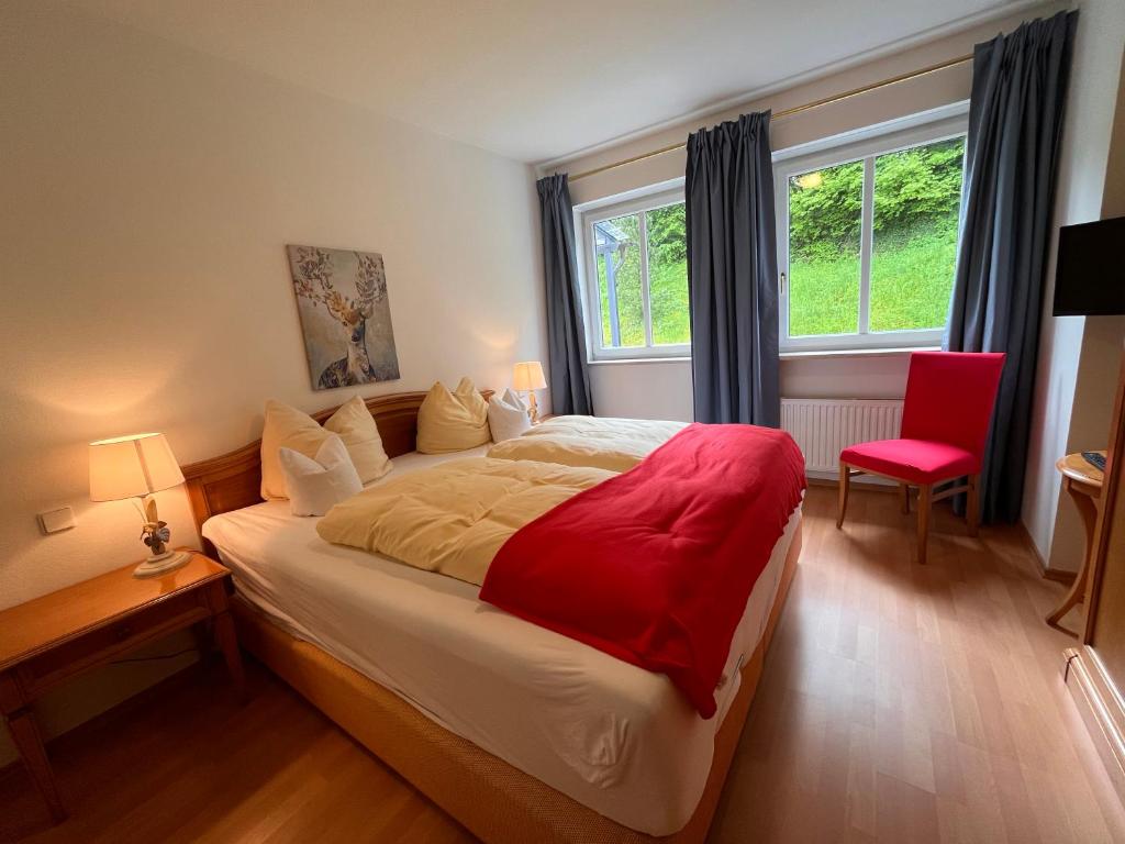 ein Schlafzimmer mit einem großen Bett mit einer roten Decke in der Unterkunft Ferienwohnungen Tivoli in Bad Reichenhall