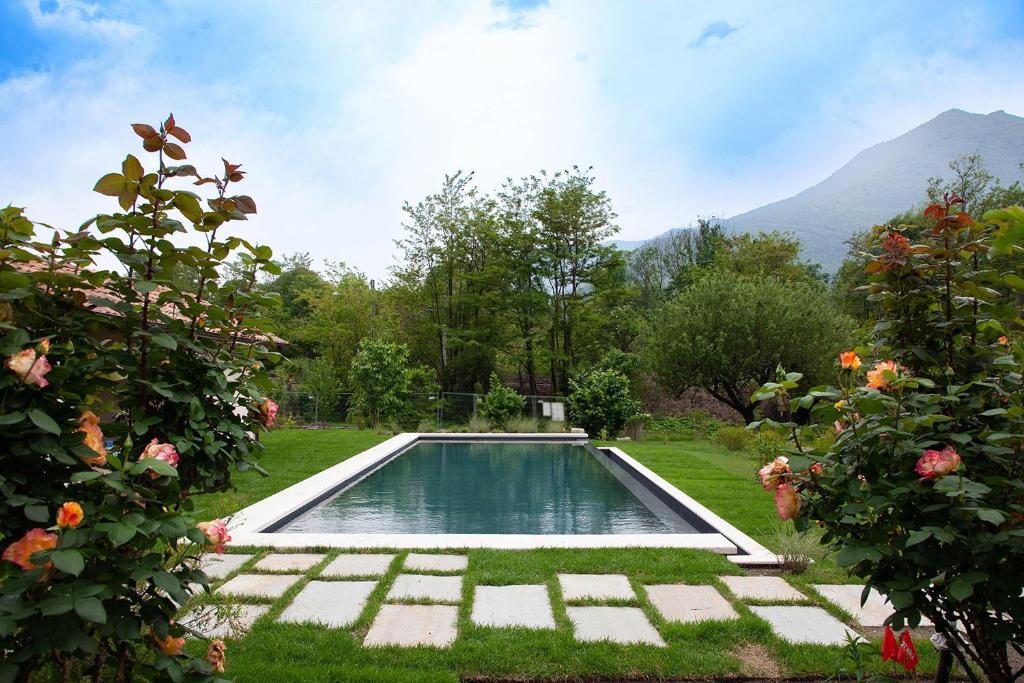 a swimming pool in the middle of a yard with flowers at B&B I Corni di Nibbio in Mergozzo