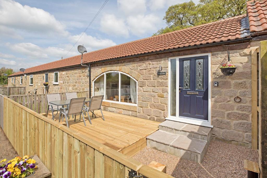 a wooden deck with a table and chairs on a house at Tom's cabin in Knaresborough