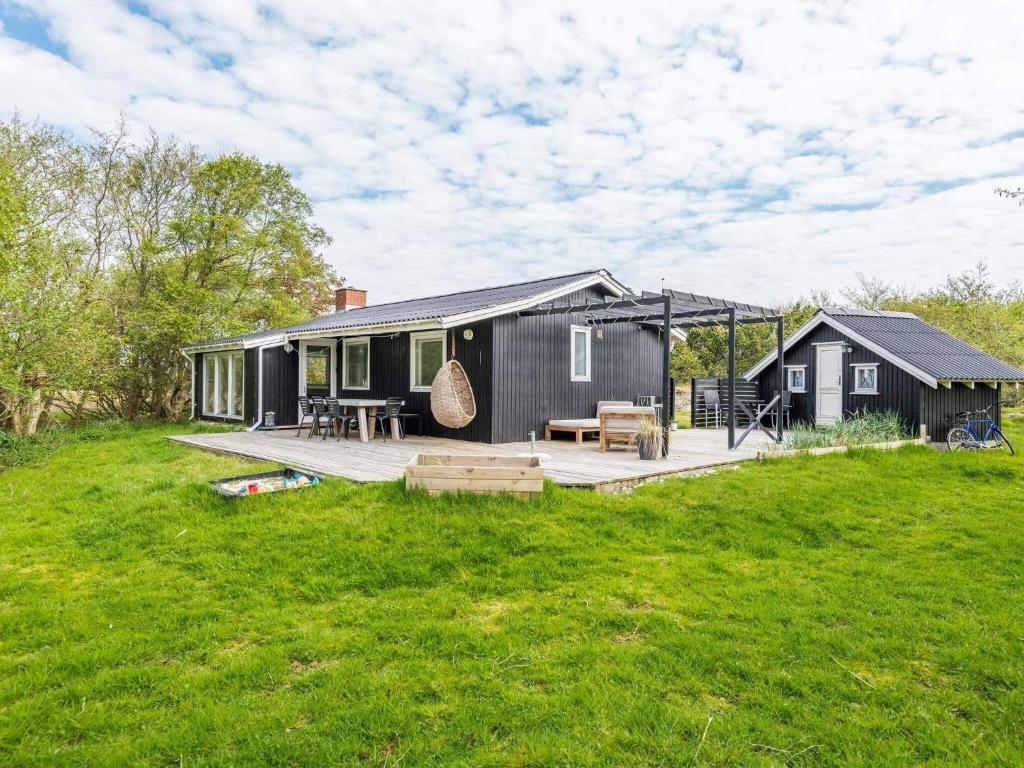 een zwart huis met een terras en een tuin bij Holiday home Fanø CCVII in Fanø