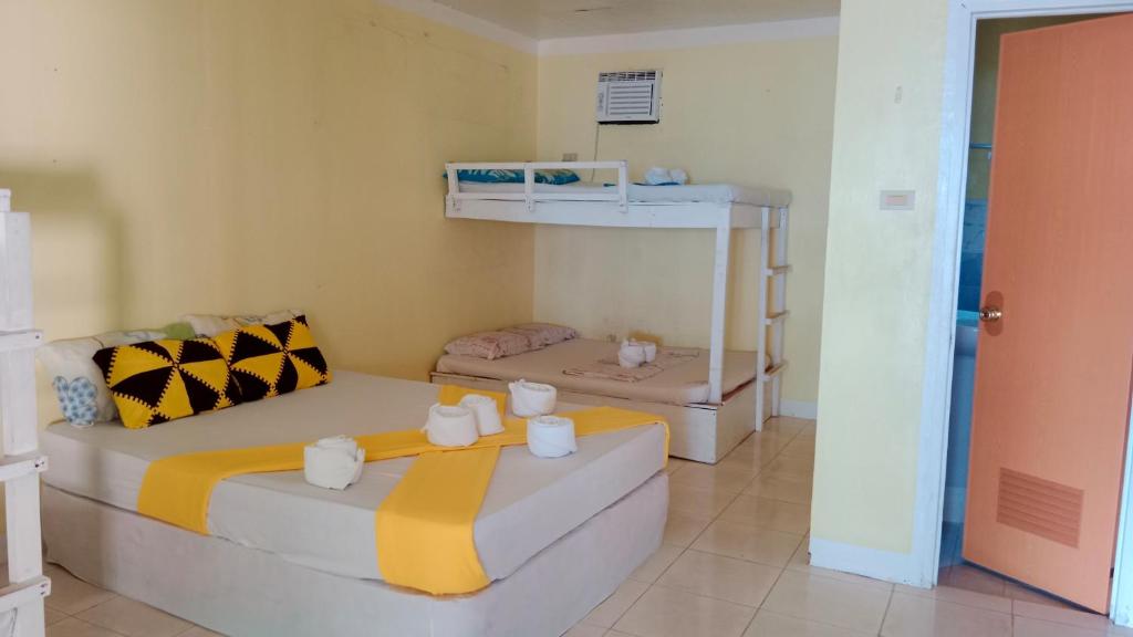 1 dormitorio con 2 camas y 1 litera en Ricks Mangrove Beach Resort, en Maricaban