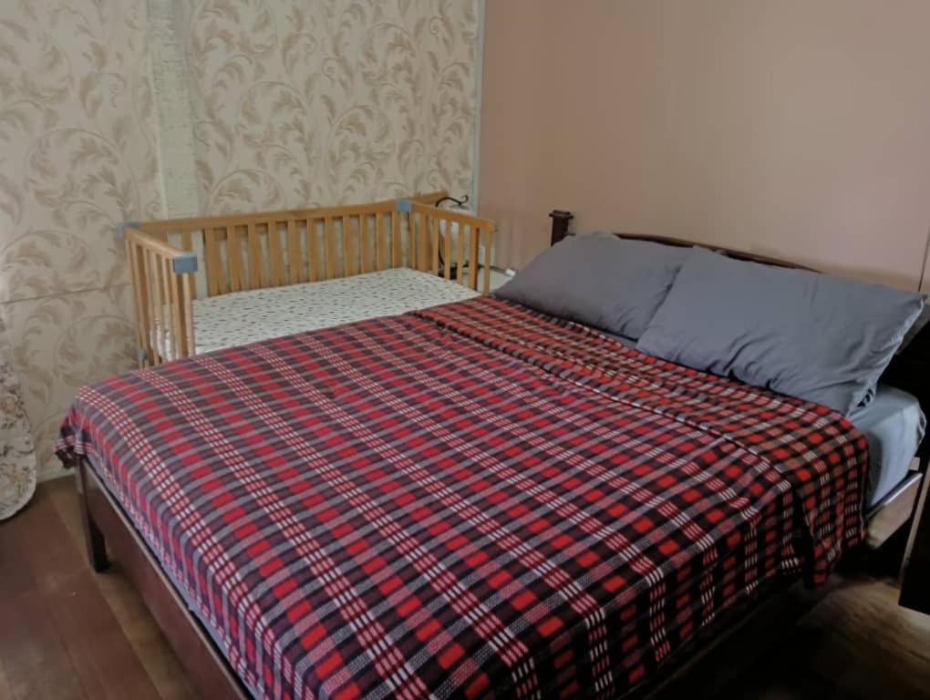 - une chambre avec un lit et une couverture tressée dans l'établissement Fusion Villa, à Bedung
