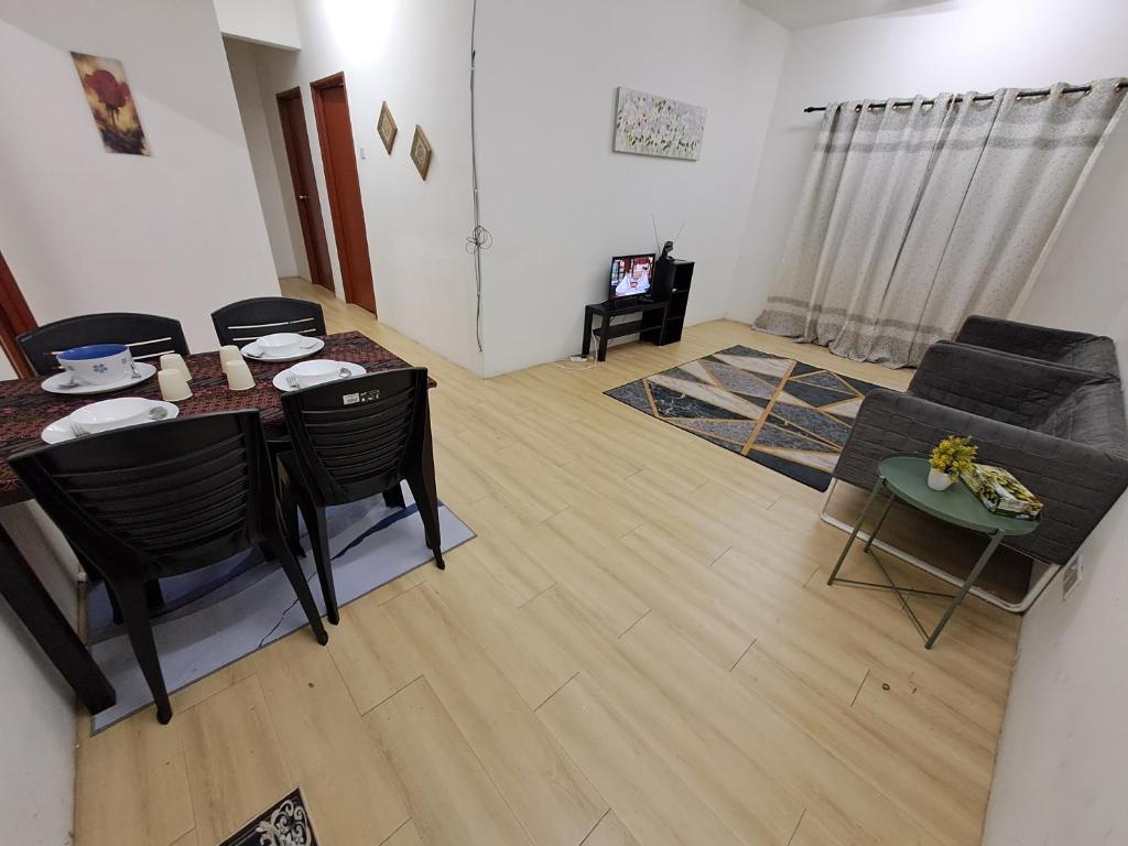 a living room with a table and chairs and a couch at 1201 Apartment Ladang Tok Pelam TepiPantaiBatuBuruk in Kuala Terengganu
