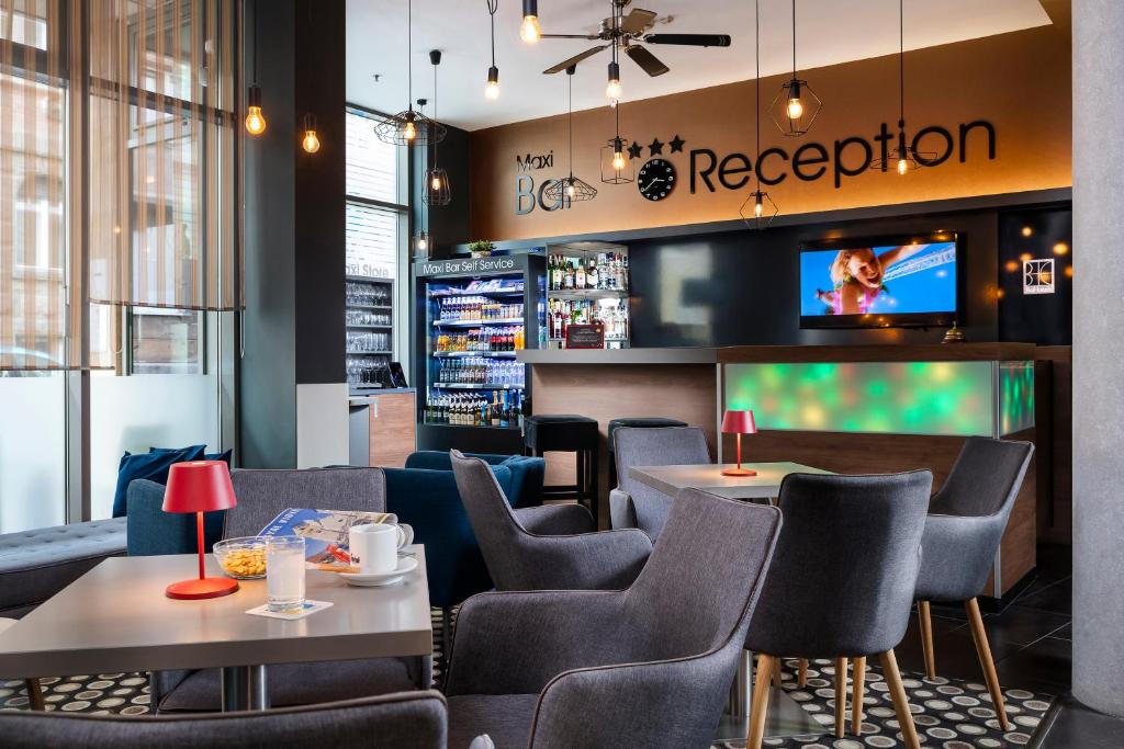 restauracja ze stołami i krzesłami oraz telewizorem w obiekcie Bo18 Hotel Superior w Budapeszcie