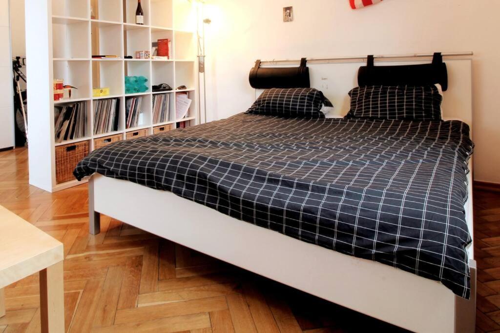 ein Bett mit einer schwarzen und weißen karierten Bettdecke in einem Schlafzimmer in der Unterkunft SPACIOUS for BIG GROUPS OKTOBERFEST / BAUMA in München