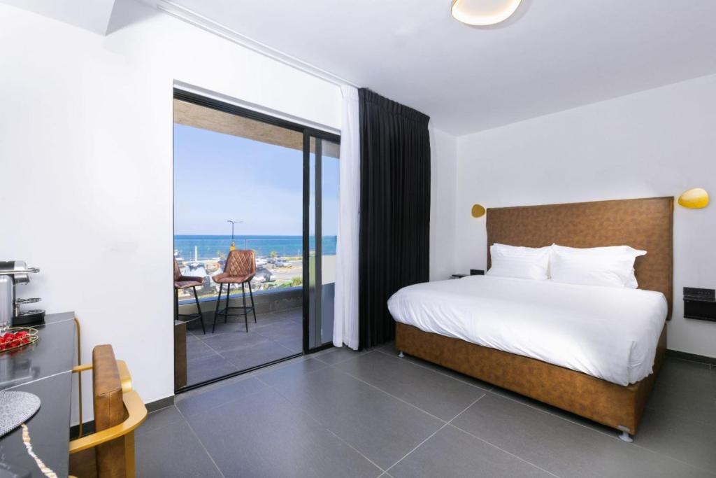 1 dormitorio con cama y vistas al océano en מלון בוטיק H34 en Nahariyya