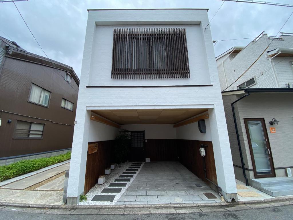 Un edificio blanco con una gran ventana en la parte superior. en 継TSUNAGU 玉鬘Tamakazura, en Kioto