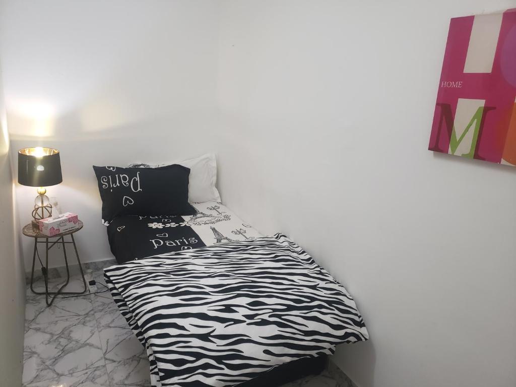 a bedroom with a black and white comforter on a bed at Comfy zone in Abu Dhabi