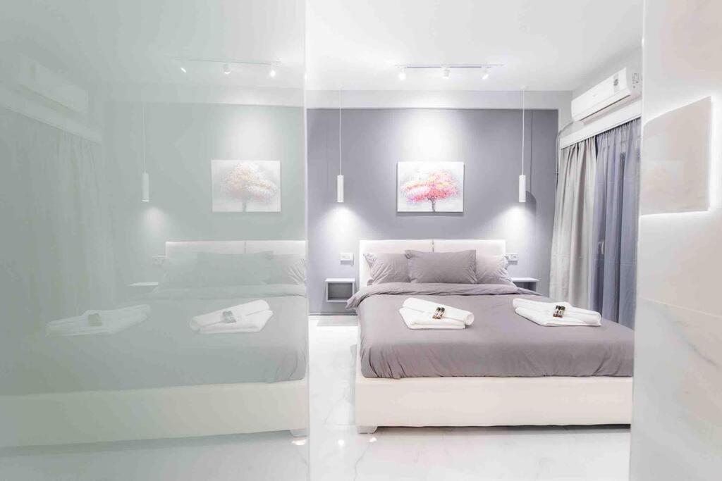 two pictures of a bedroom with a bed and a tub at Lux seaside apartment by Volos hospitality in Volos