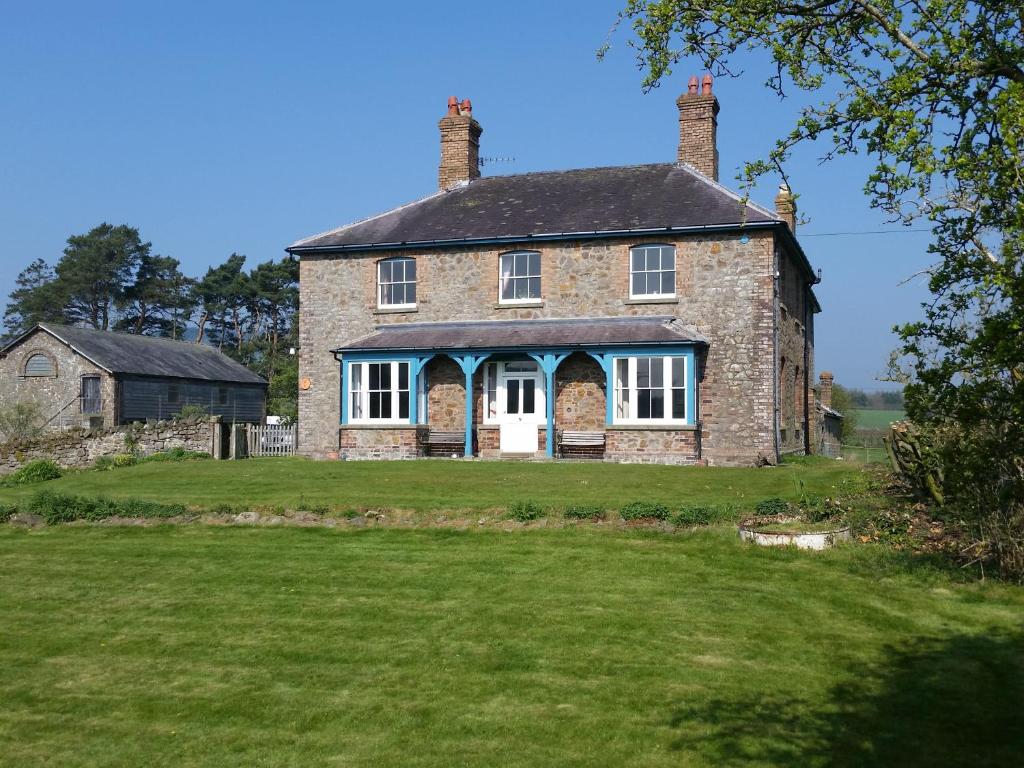 an old brick house on a grass field at Upper Letton Farm in Leintwardine