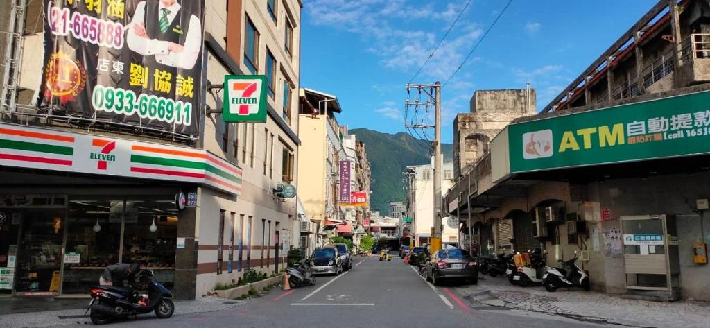 una calle de la ciudad con edificios y coches aparcados en la calle en 歐巴虎將去旅行오빠 & フーちゃん系列一招待所週年感恩活動 近車站慈濟 後站莊太太民宿 en Hualien