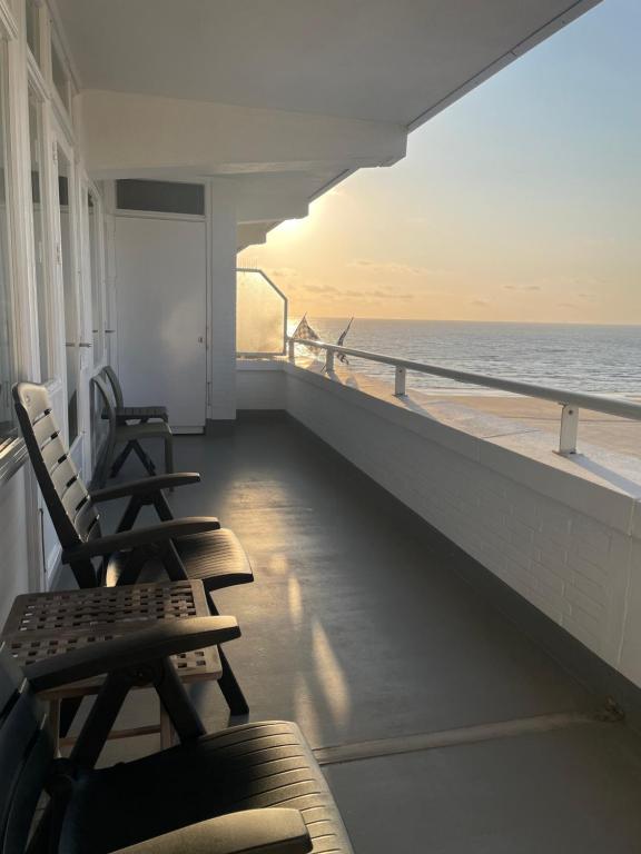 ein Balkon mit zwei Stühlen und Blick auf das Meer in der Unterkunft North Sea Spirit in Zandvoort