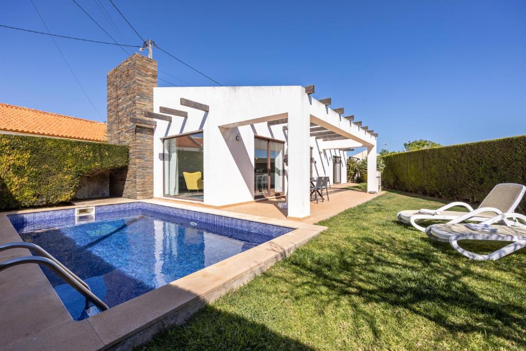 a villa with a swimming pool and a house at Villa Botelha in Sagres