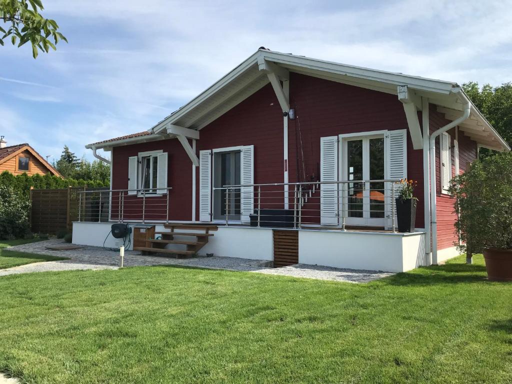 una casa roja con porche y patio en Haus Fjord, en Am See