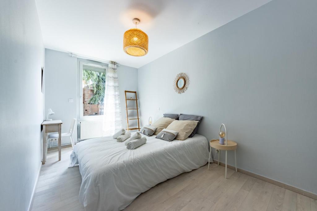 a white bedroom with a bed and a ladder at Le beau T3 de St Jory climatisation in Saint-Jory