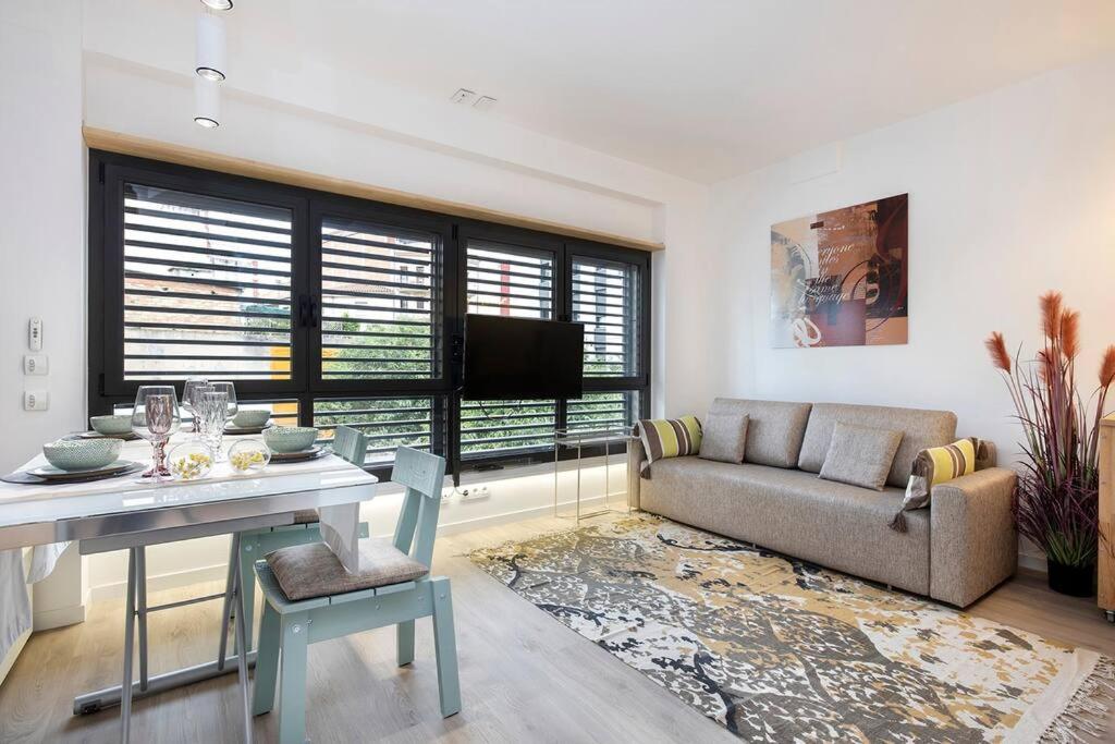 ein Wohnzimmer mit einem Tisch und einem Sofa in der Unterkunft II-I Hub Luxury New Apartments in Barcelona
