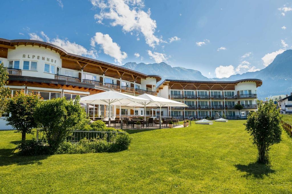 a hotel with a lawn in front of a building at Best Western Plus Hotel Alpenhof in Oberstdorf