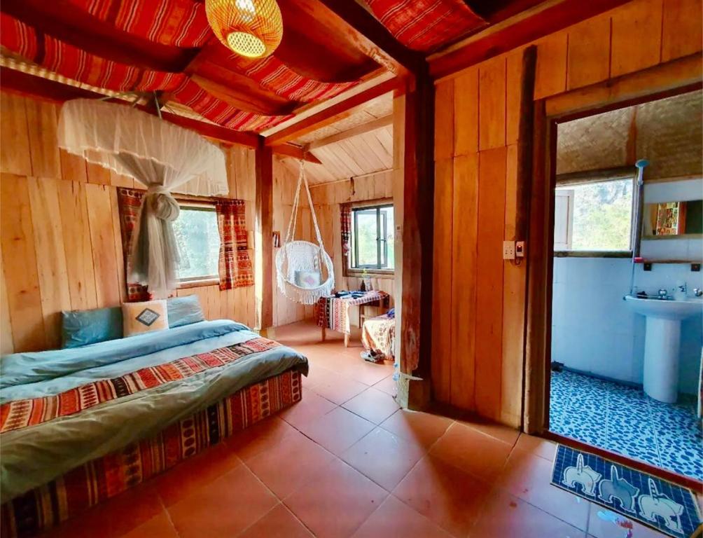 ein Schlafzimmer mit einem Bett in einem Holzzimmer in der Unterkunft Du Gia Village Homestay-Lana in Làng Cac