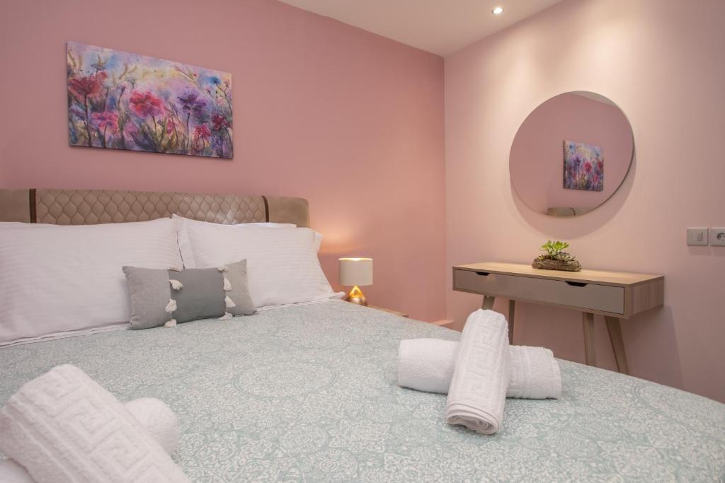 a bedroom with a large bed and a mirror at Hypatia Suites in Zakynthos Town