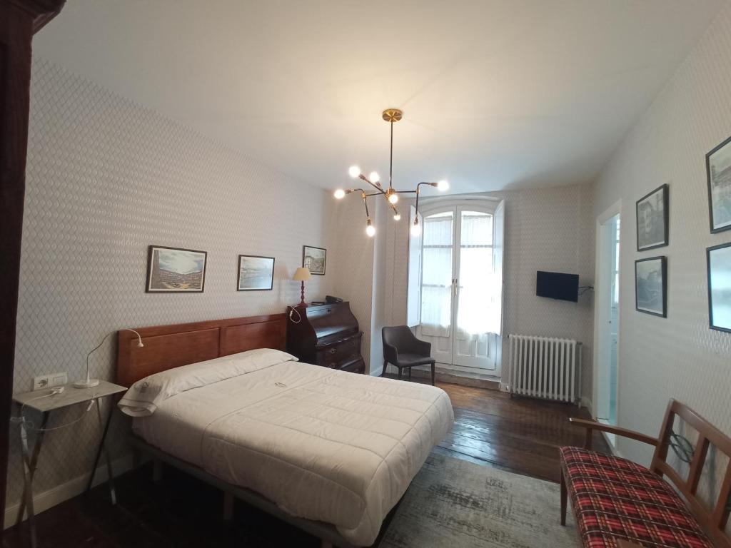 a bedroom with a bed and a desk and a chair at Hotel Ormazabal in Bergara