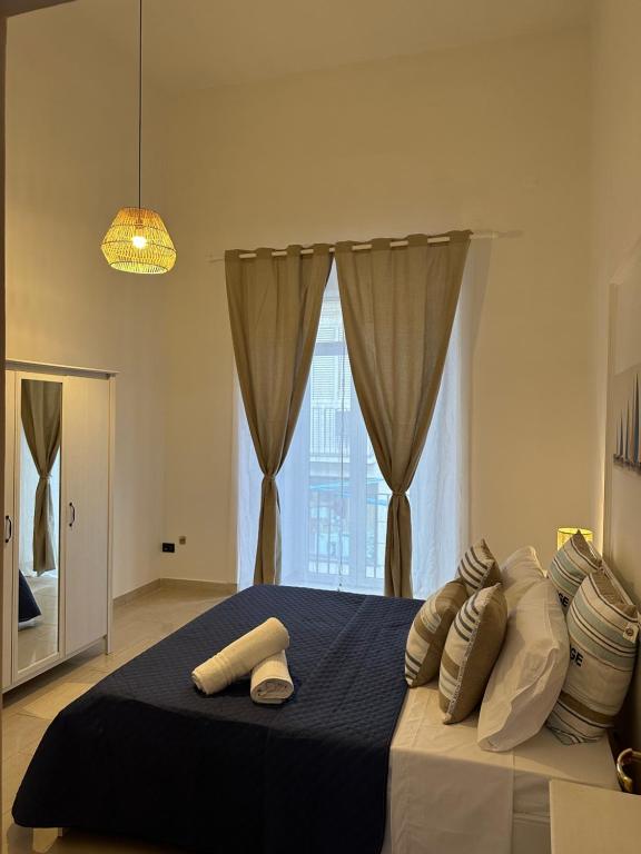 una camera da letto con letto, cuscini e finestra di B&B mazzocchi a Santa Maria Capua Vetere