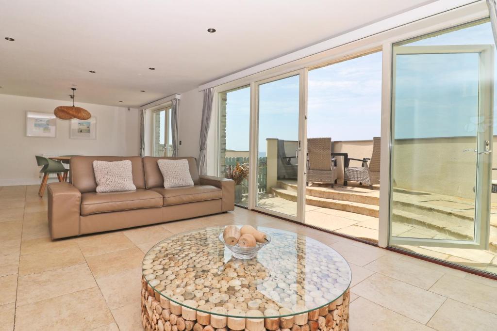 a living room with a couch and a table at APARTMENT BY THE BEACH The Foxcove in St Merryn