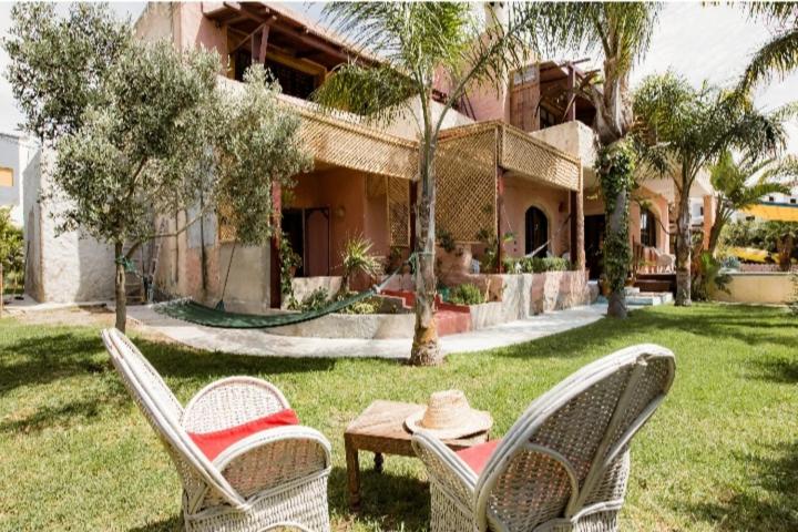 two chairs and a table in front of a house at Hajrienne guest house in Tangier