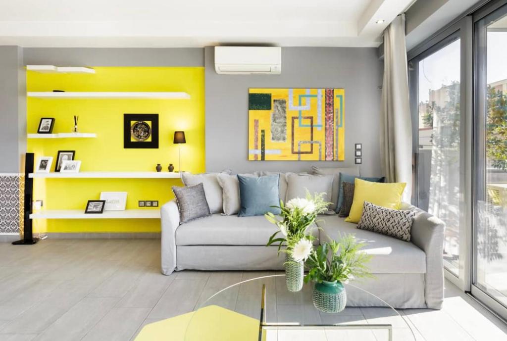 a living room with a couch and a yellow wall at Stylish Boutique Loft With Private Balcony in Athens