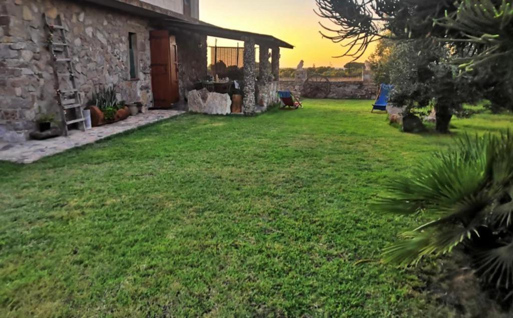 ein Hof eines Hauses mit grünem Rasen in der Unterkunft Villetta immersa nella Natura in Calasetta