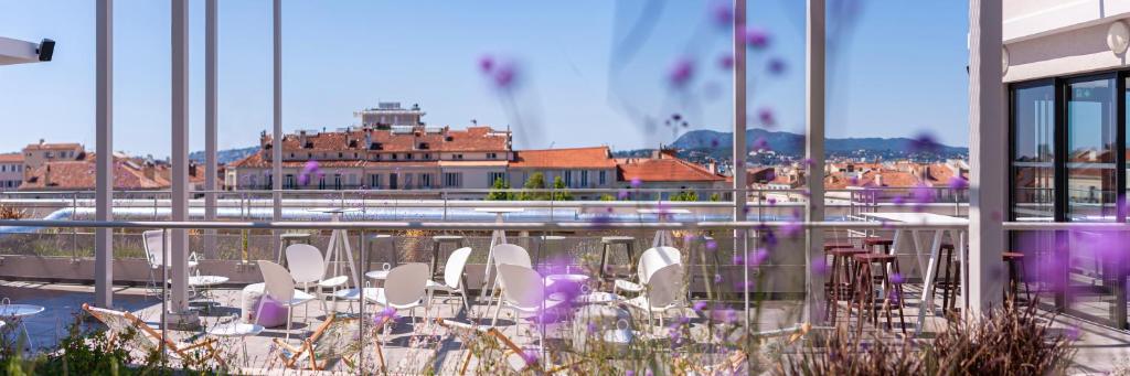 a balcony with white chairs and a view of a building at Apparthotel Privilodges Toulon Centre Gare in Toulon
