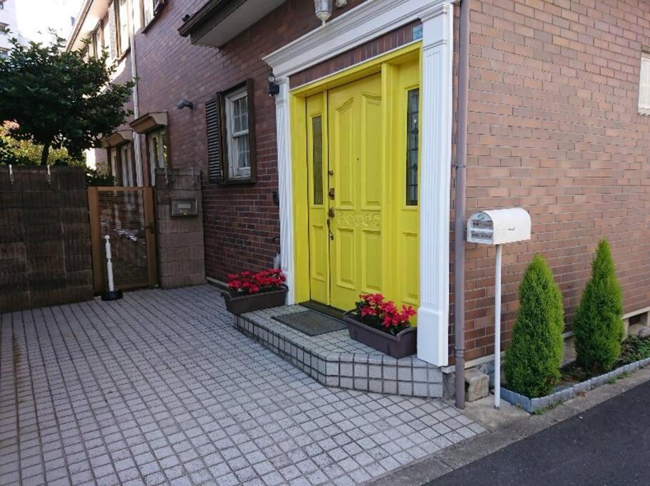 a yellow door on the side of a brick house at Urban Residence Ikebukuro East in Tokyo