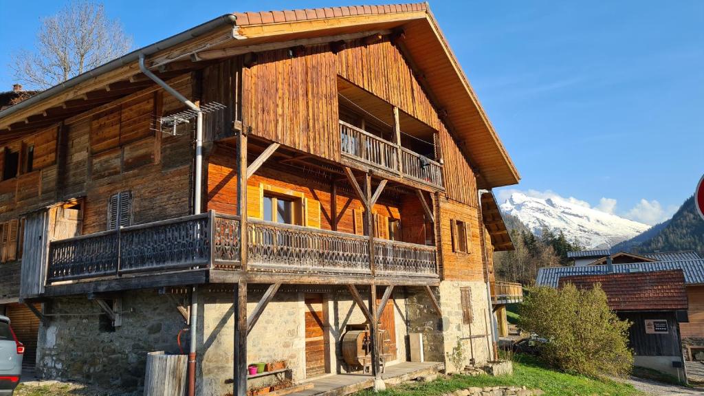 un gran edificio de madera con balcón. en Bas de chalet au coeur des Aravis, entre lac et montagne, en Saint-Jean-de-Sixt