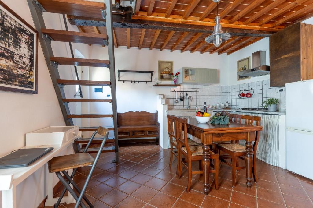 cocina con escalera de caracol, mesa y sillas en Hamlet in the Countryside, en Fauglia