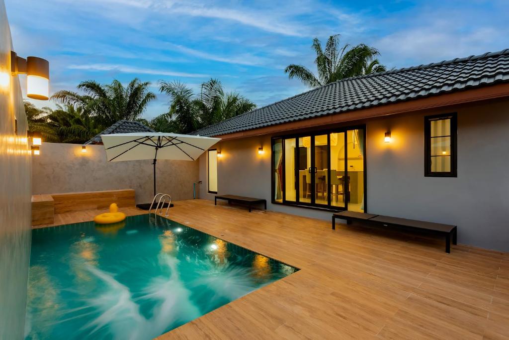 a villa with a swimming pool and a house at Neenlawat Riverside in Surat Thani