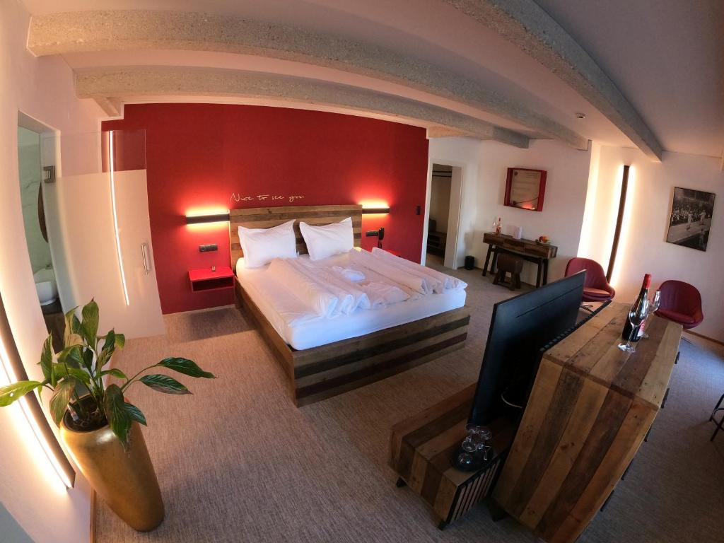 a bedroom with a bed with a red wall at Sporthotel Igls in Innsbruck