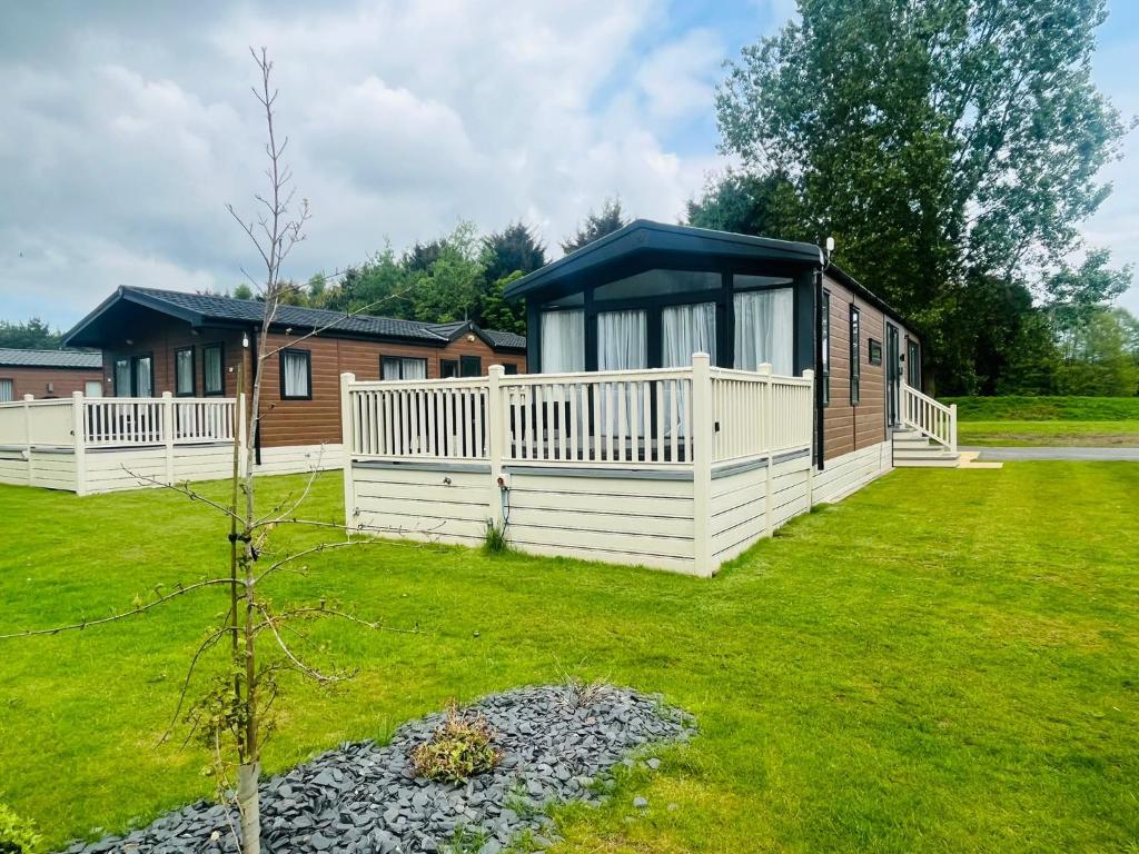 a cabin in a yard with a green lawn at Ebor Lodge With Hot Tub in Pocklington