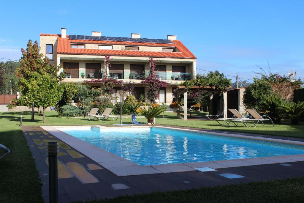 a swimming pool in front of a building at Apartamentos As Lagoas in O Grove