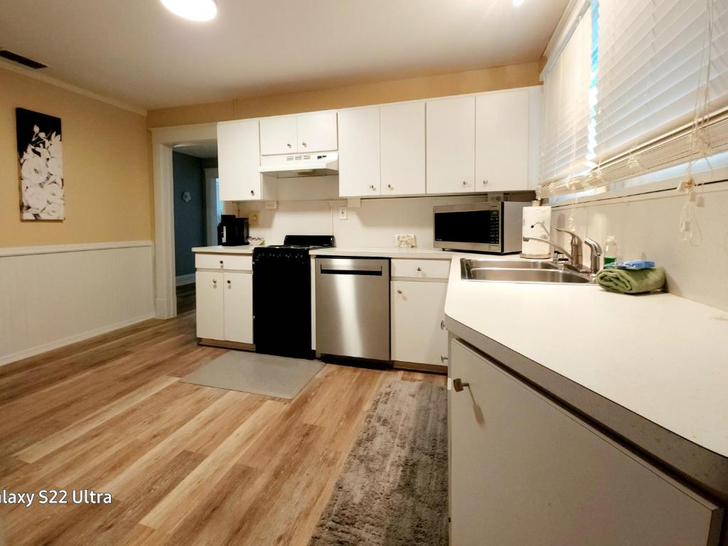 an empty kitchen with white cabinets and a sink at EXQUISITE FAMILY HOME in Lakeland