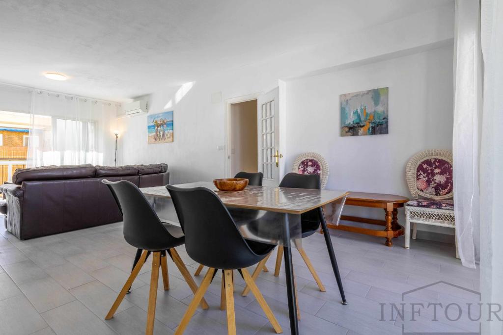 ein Wohnzimmer mit einem Esstisch und Stühlen in der Unterkunft Inftour Primavera Apartamento in Calpe