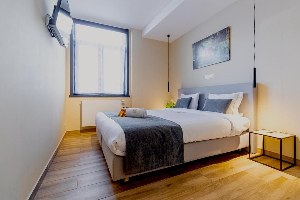 a bedroom with a large bed and a large window at JT HOMES in Bruges