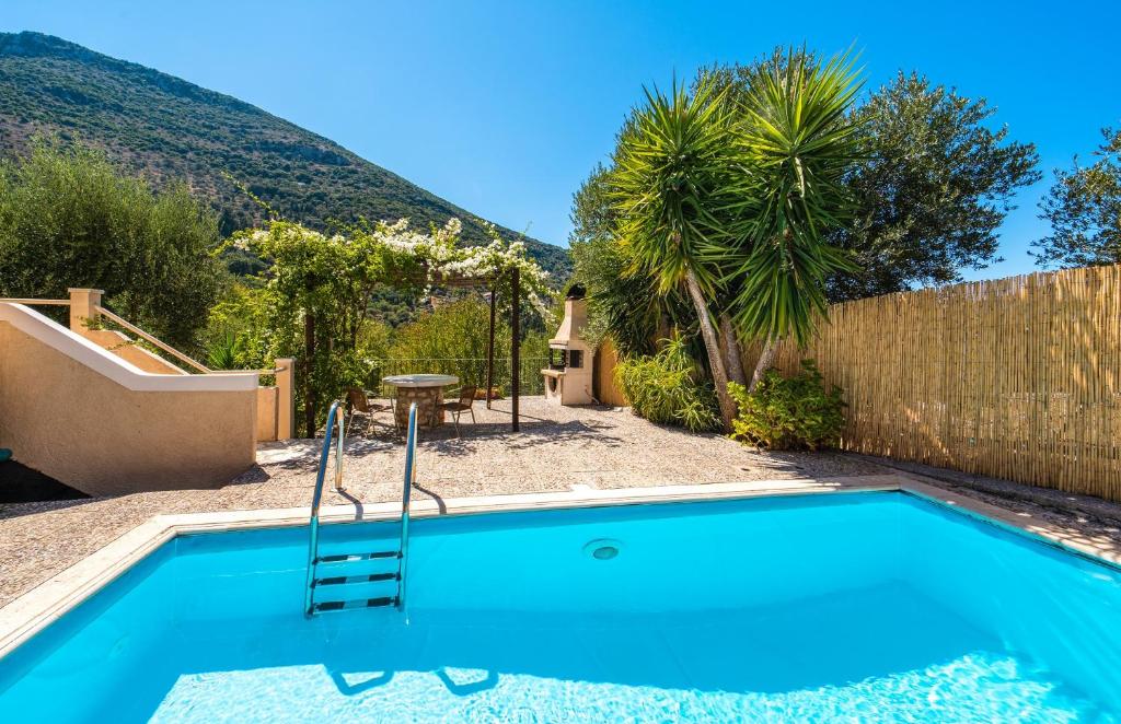 a pool in the backyard of a house with a hill in the background at Arethusa Cottage in Vathi, Ithaka