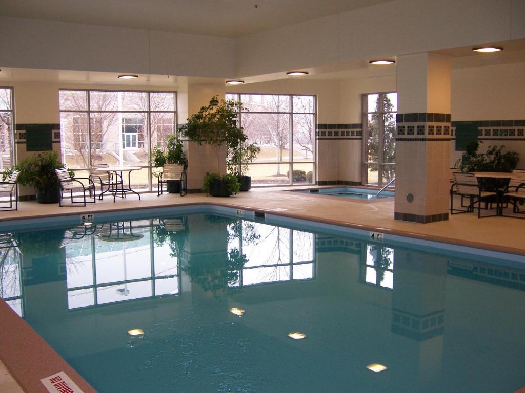 a large swimming pool in a building with windows at Wyndham Moline on John Deere Commons in Moline