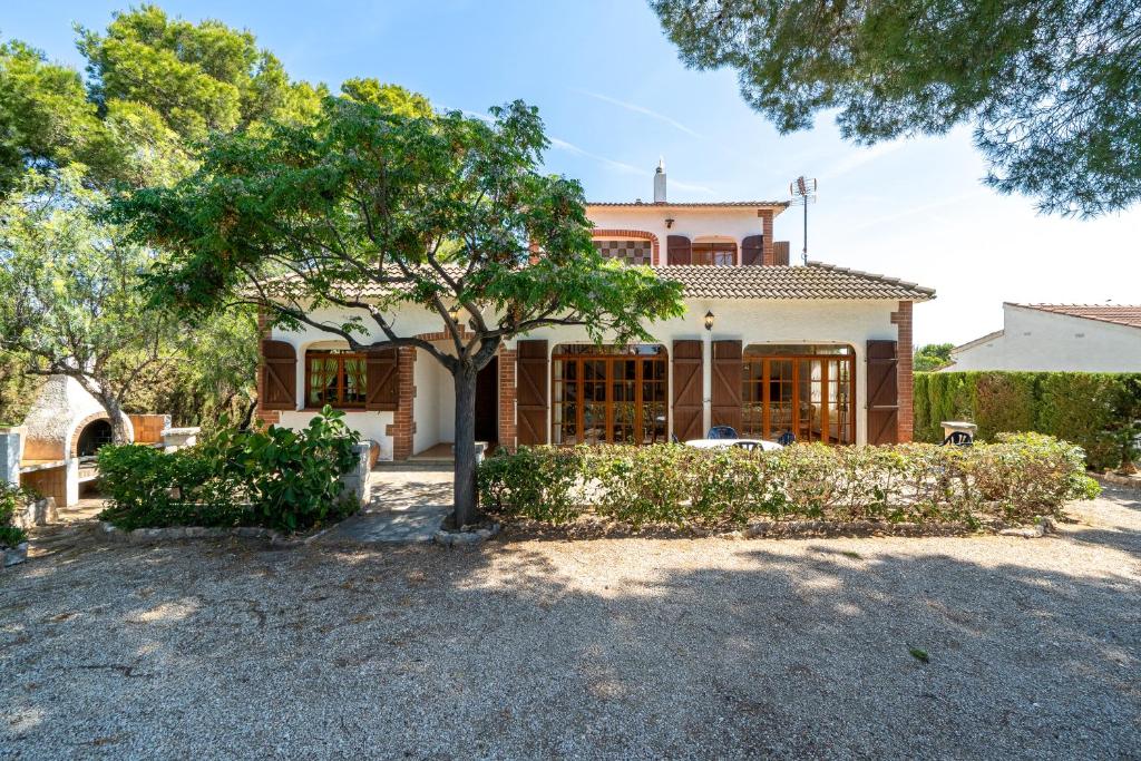 a house with a tree in front of it at Hauzify I Casa Cardona in Les tres Cales