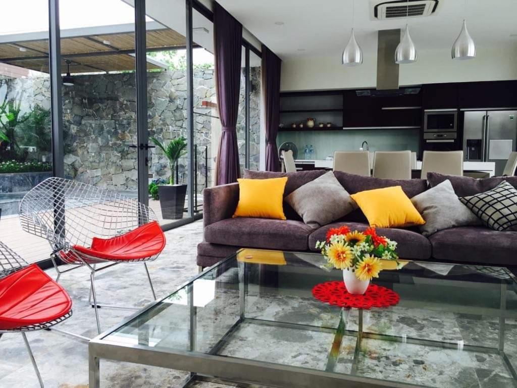 sala de estar con sofá y mesa de cristal en Flamingo Villa Đỗ Quyên en Vĩnh Phúc