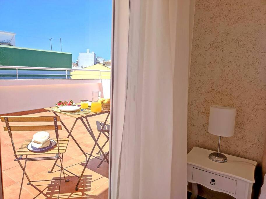 a room with a balcony with a table and a lamp at Lovely Terrace Apart. Downtown in Faro
